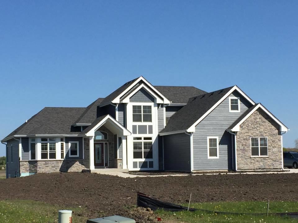 The stunning exterior of this two story house features vinyl siding and real stone Two Story House Exterior
